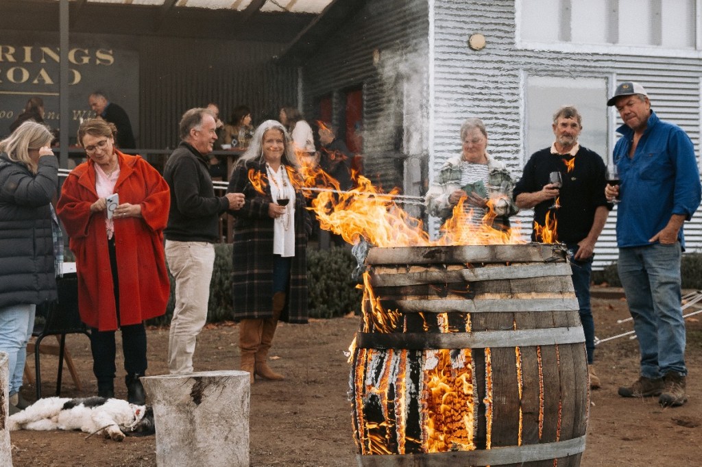 People gather around an outdoor firepit at Gutsy Kangaroo Island